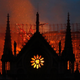 The glow of flames can be seen through the windows of Notre Dame as fire ravaged the centuries-old cathedral in Paris April 15, 2019.